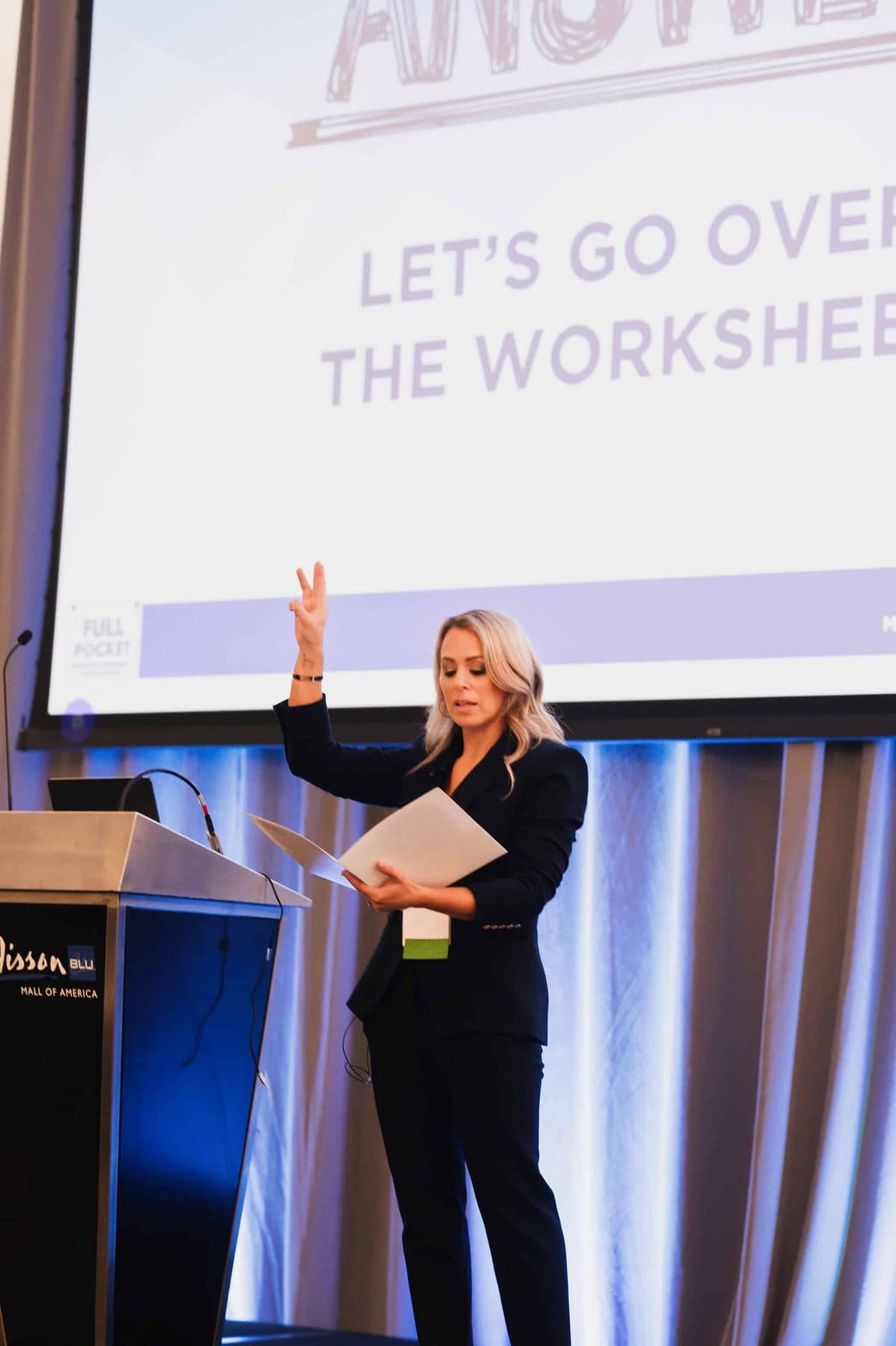 Marni Blythe on stage, leading a room through a workshop exercise